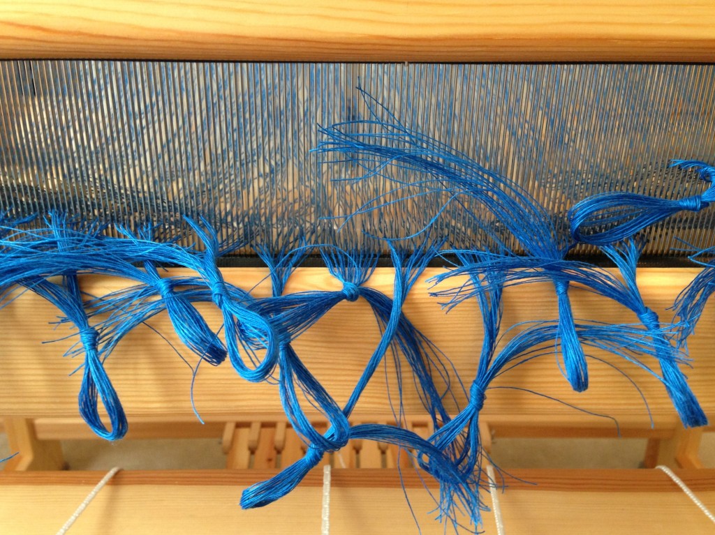 Linen ends are sleyed through the reed.