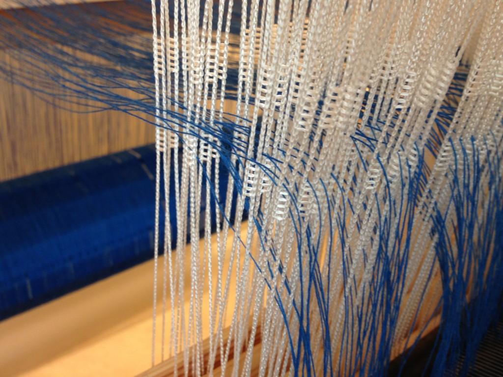 Linen singles warp is threaded in the heddles.