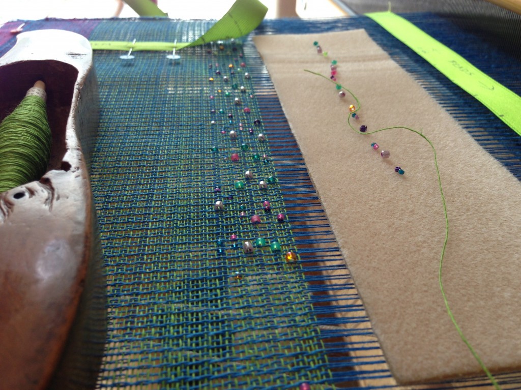 Weaving small glass beads into the linen textile.
