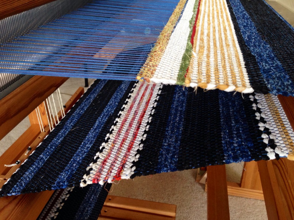 Rag Rug on the loom. Striped hem is followed by scrap strips to secure the wefts.