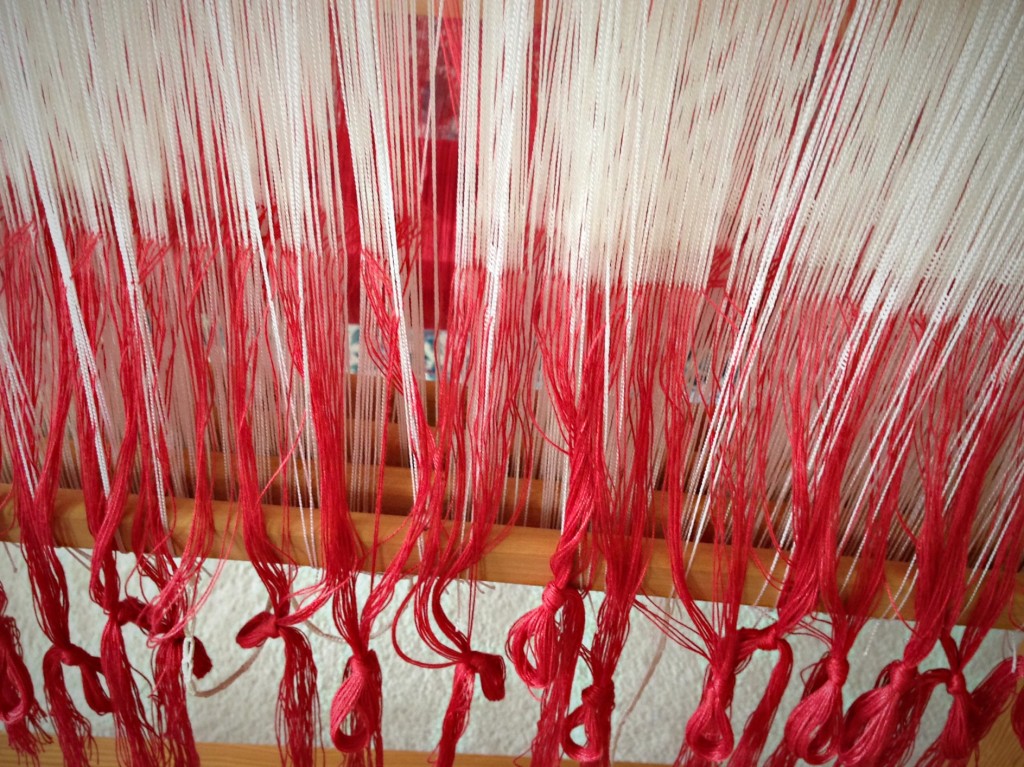 Threading heddles with coral bamboo thread for huck lace.