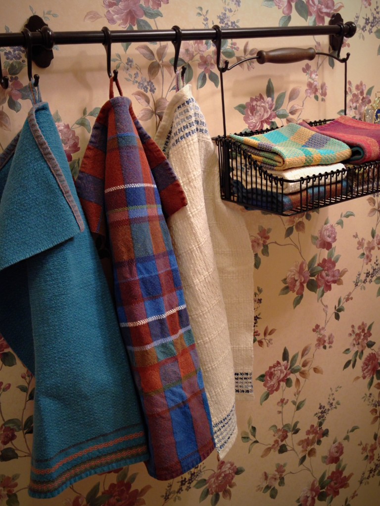 Ikea basket and hooks hold handwoven towels for guests.