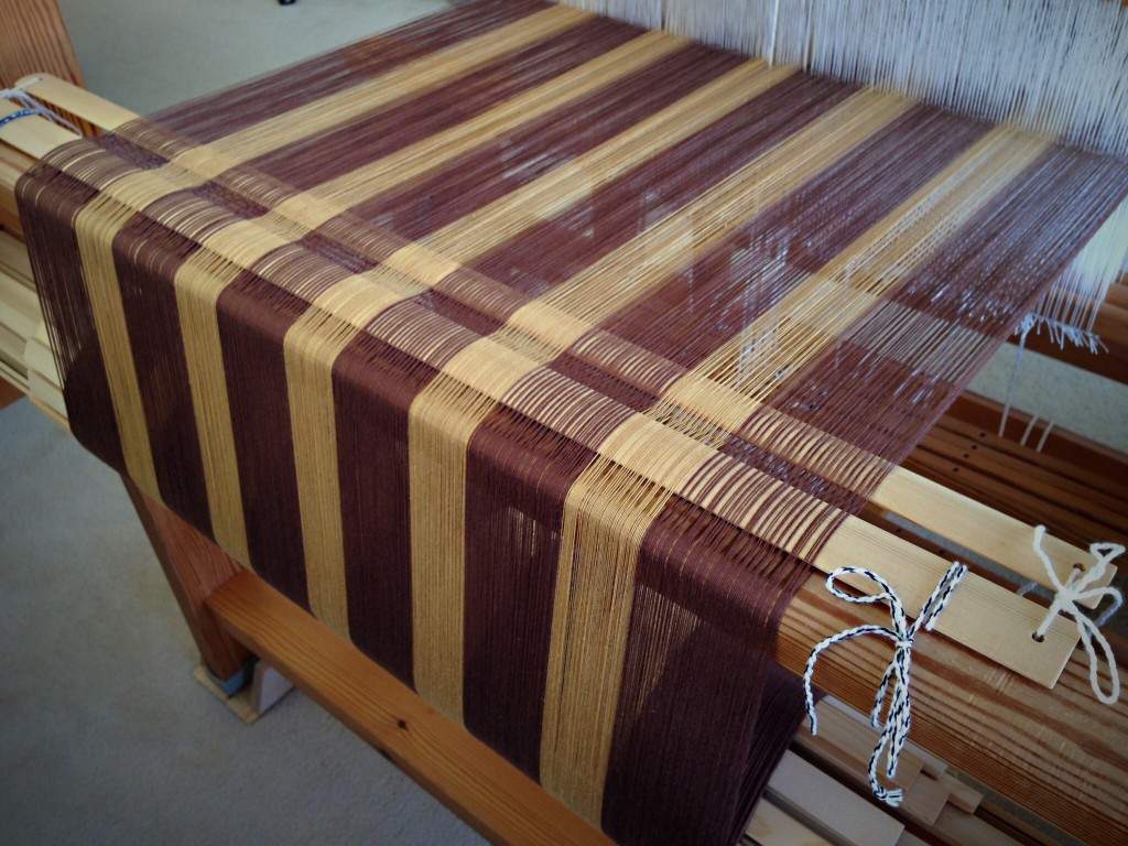 Striped cotton warp for tea towels. Lease sticks tied to back beam.