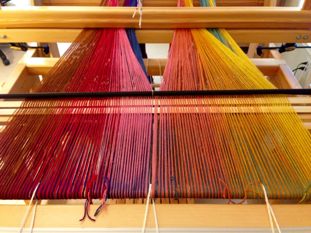 Upper layer of double weave is spread on the loom.