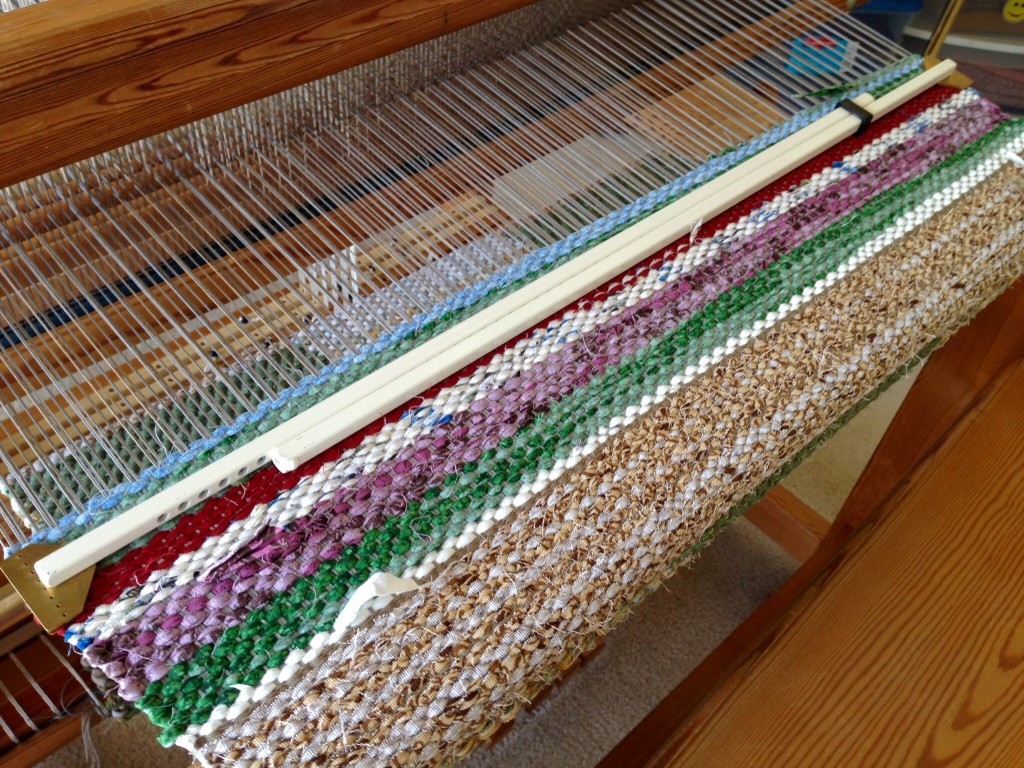 Temple in place in scrap weft between rag rugs. Temple tips.