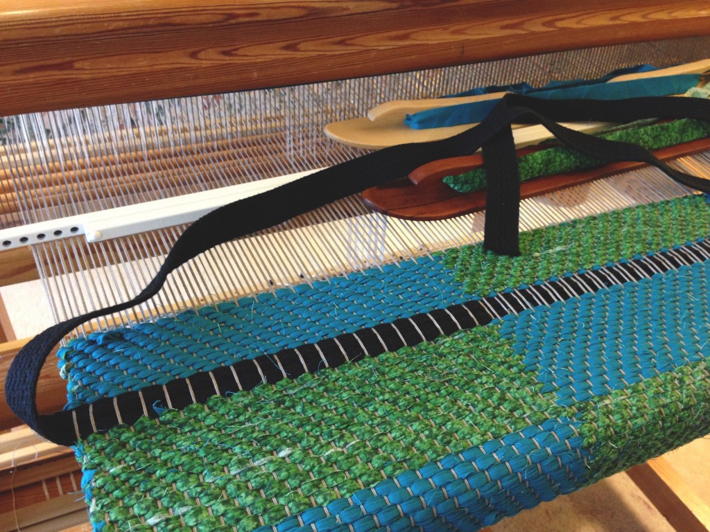Weaving bag handles into the rag rug bag.