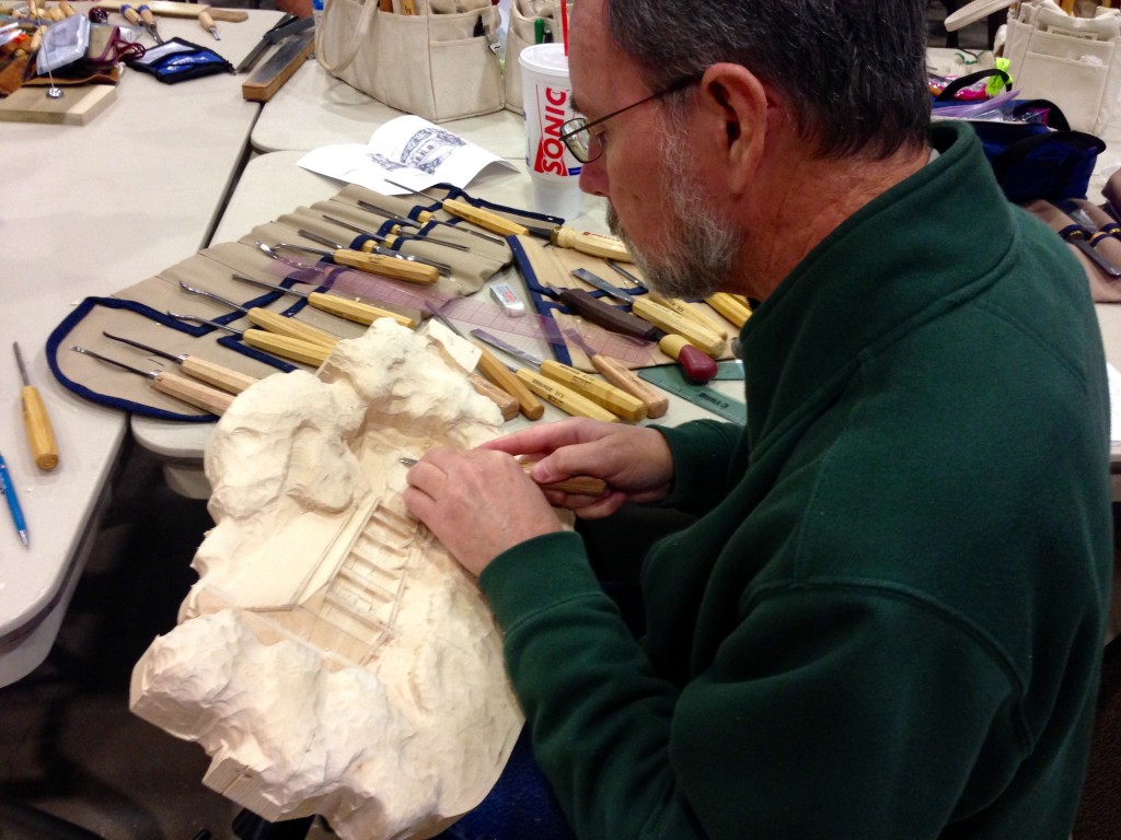 Woodcarver doing relief carving.