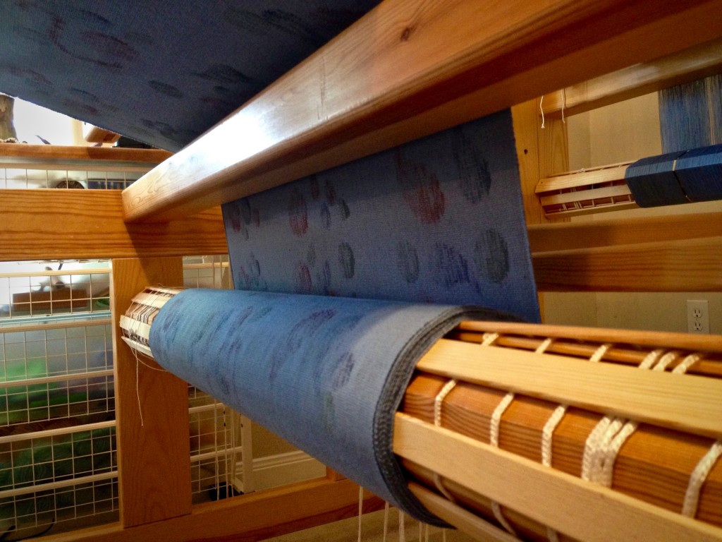 Printed fabric collects on the cloth beam.