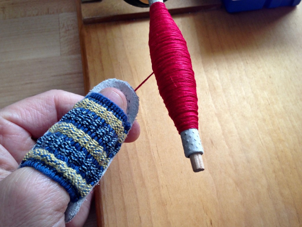 Leather thumb guard prevents cuts while winding linen quills.