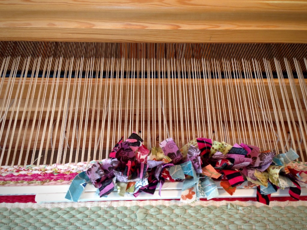 Beginning sample of rag rug weaving with rya knots.