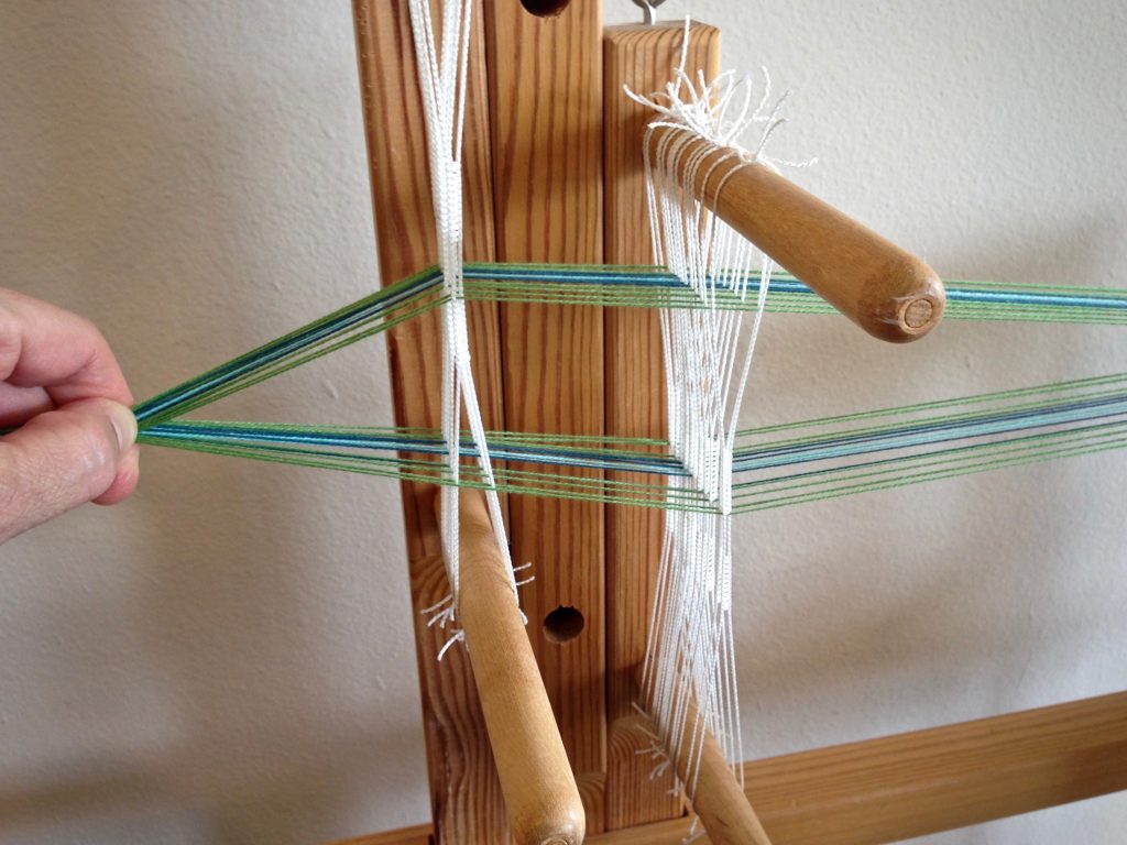 Warping the band loom.