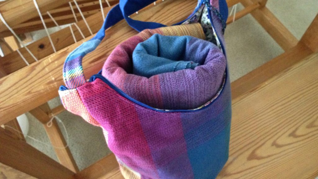 Finished handwoven handbag holds rolled baby wrap. Karen Isenhower