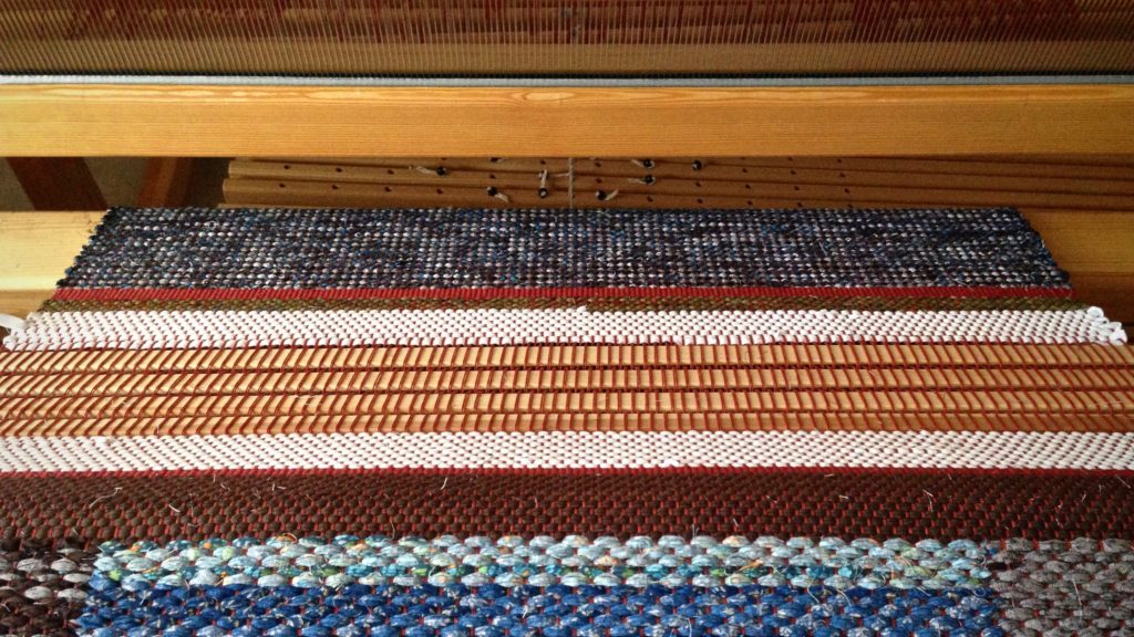 Warping slats as spacers between rag rugs.