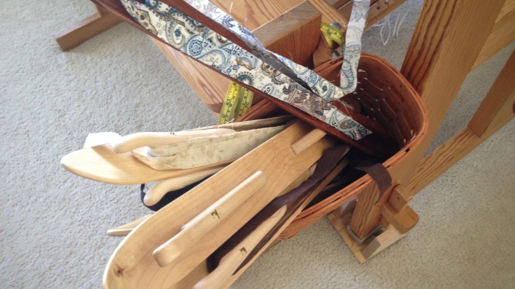 Loom bench basket holds the ski shuttles for a rosepath rag rug.