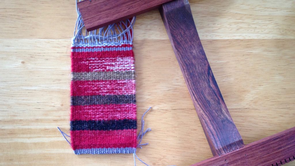 Hokett loom and small woven piece. Finishing in progress.