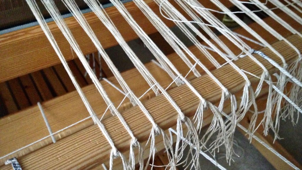 Adding the leveling string to a linen warp.