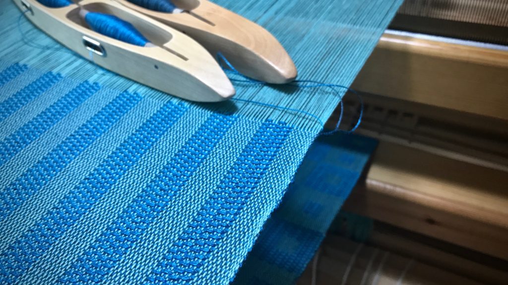 Kuvikas - Weaving lengthwise stripes on a solid-color warp.