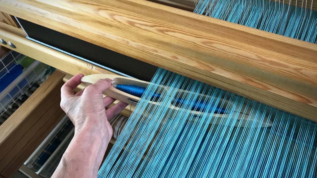 Weaving with a double-bobbin shuttle.