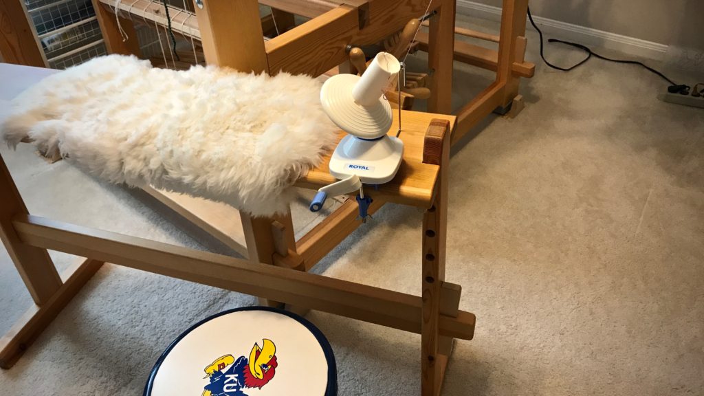 Yarn ball winder in use with umbrella swift.