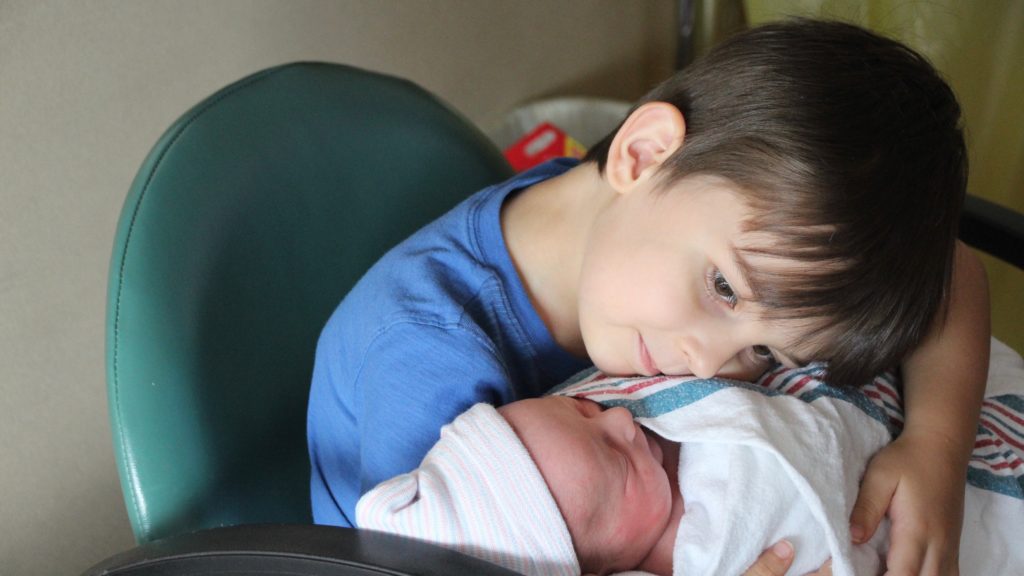 Big brother loving his new baby brother. Awww... so sweet.