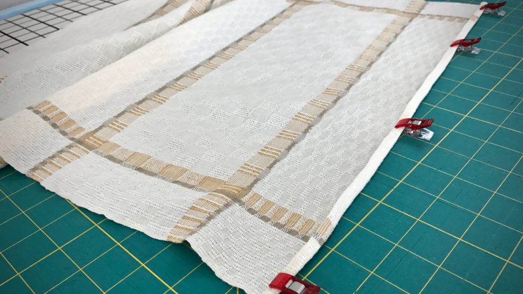 Sewing narrow hems on handwoven towels.