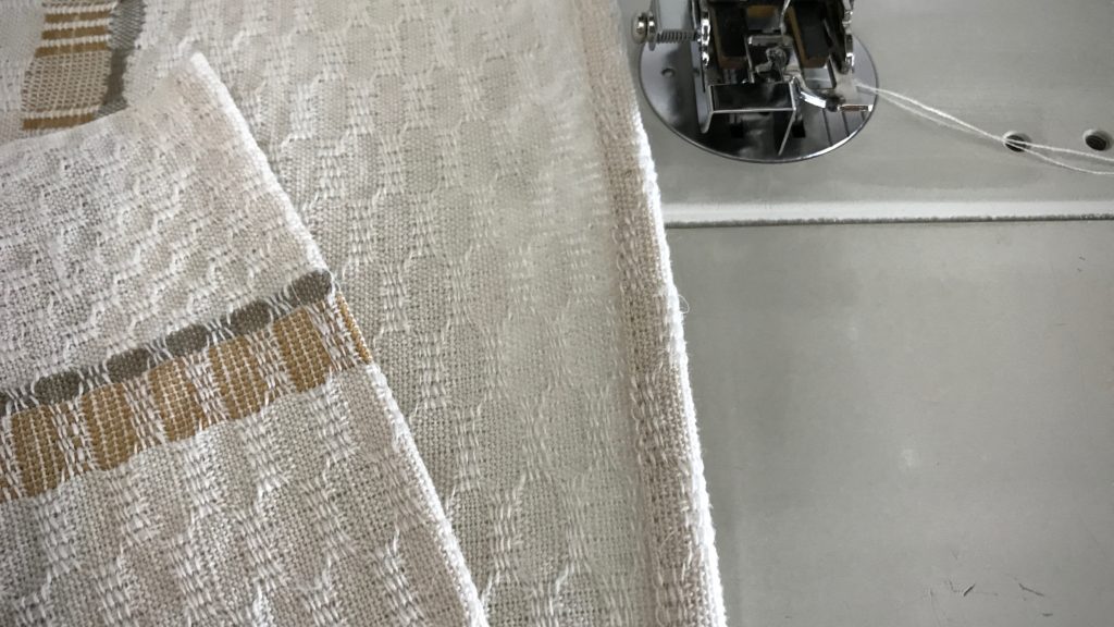 Hemming handwoven towels.