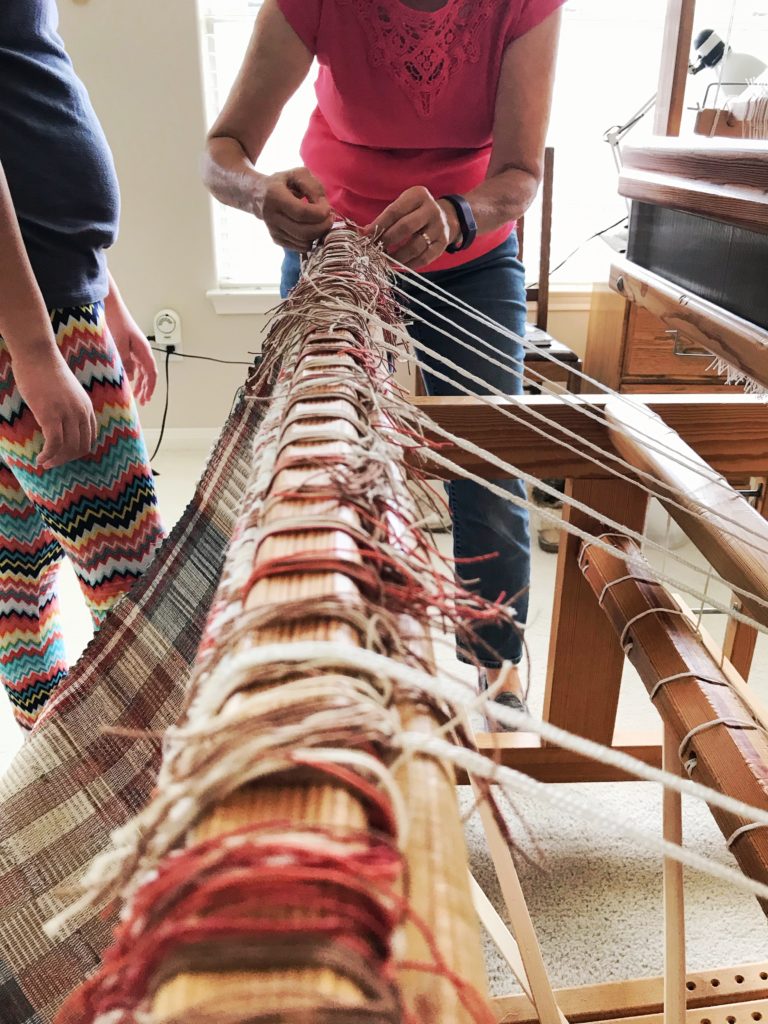 Untying the warp. Rag rugs just off the loom.