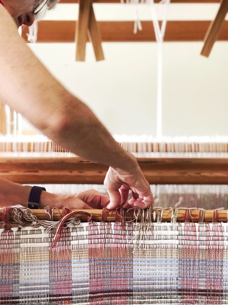 Releasing new rag rugs from the loom.