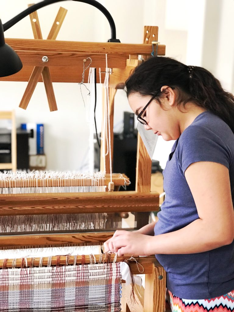 Taking new rag rugs off the loom.