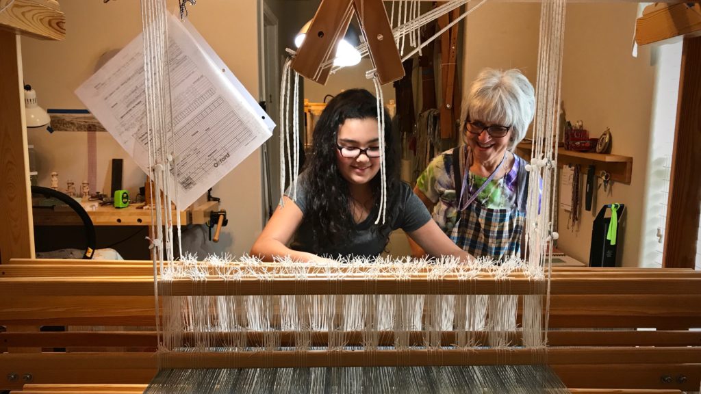 Young apprentice. First time at the loom.