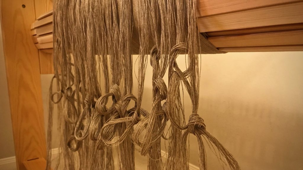 Beamed linen warp. Tied into threading groups.