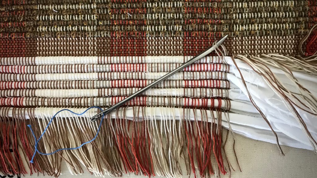 Tying warp ends into knots. Rag rug finishing.