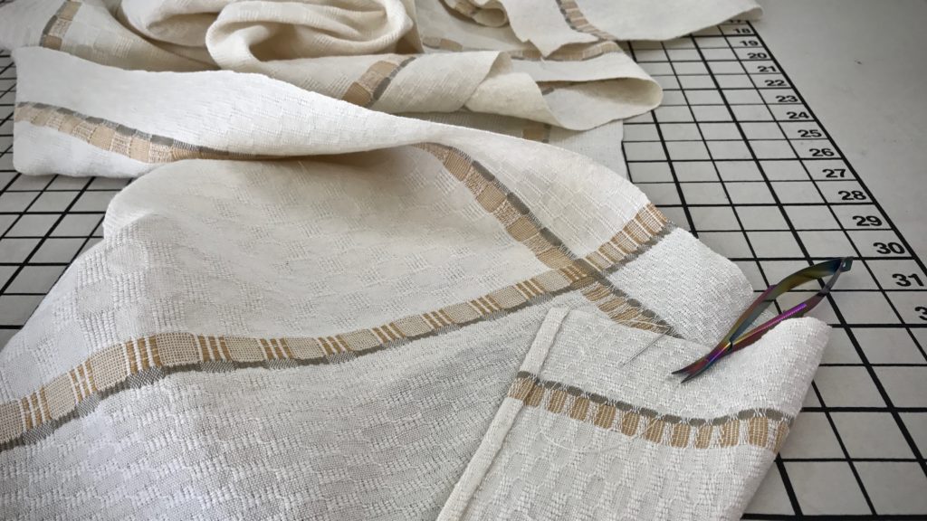 Hand hemming handwoven table runner.