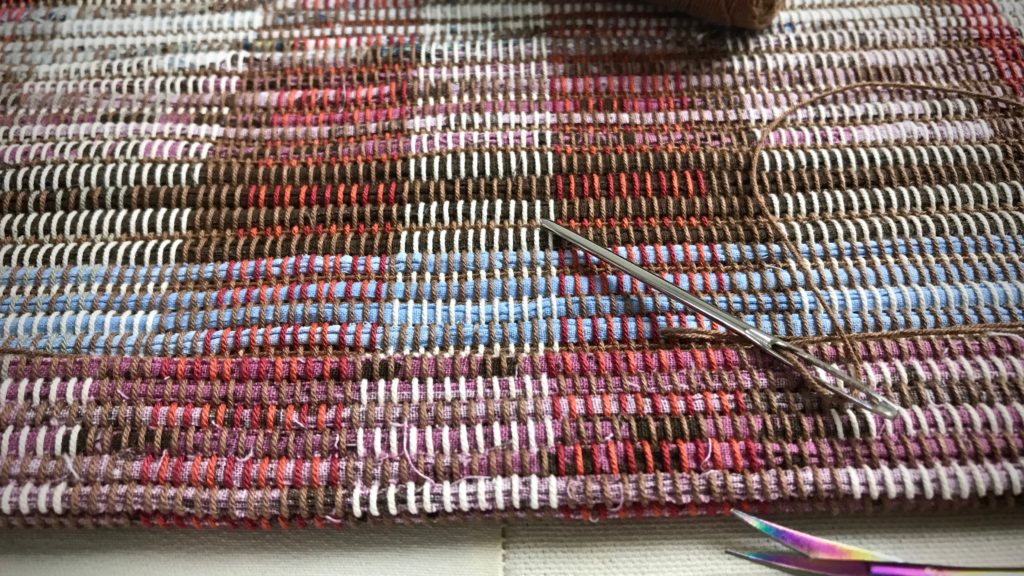 Rag rug hemming by hand.