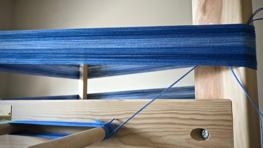 Winding a warp on a warping reel.