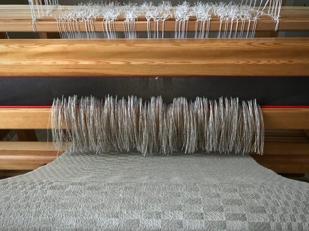 Cutting off! Linen threads flow through the reed like a waterfall.