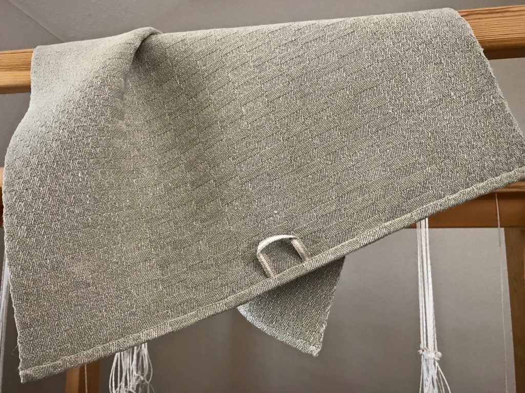 Handwoven linen towel with handwoven hanging tab.