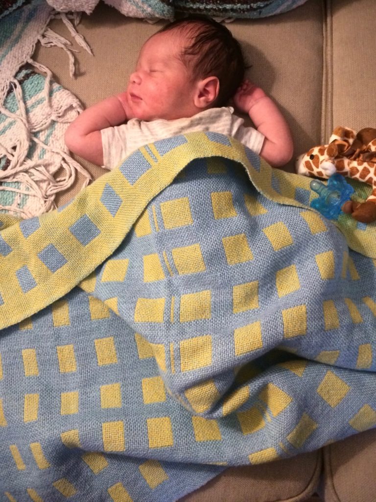 Cotton double weave baby blanket covers newborn grandson.