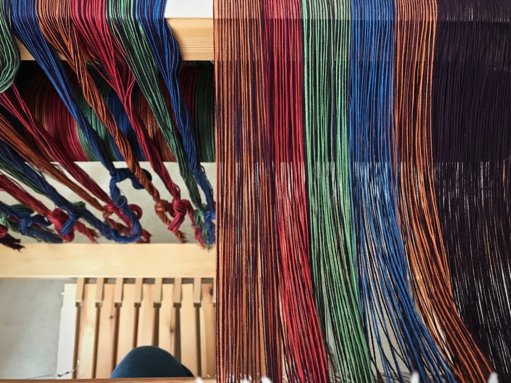 Threading heddles in my "playhouse" in the loom.