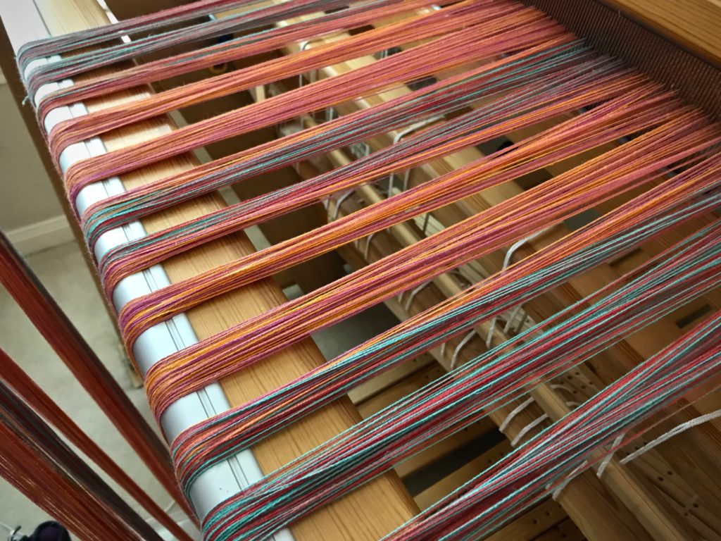 Beaming the warp with a warping trapeze.