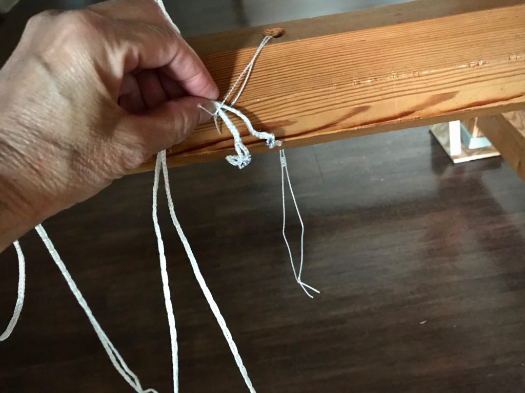 Using a spare heddle as a cord threader.