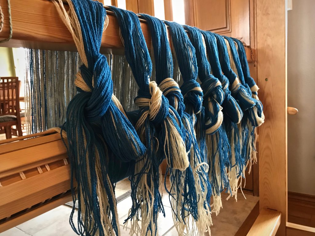 Wool warp separated into threading groups.