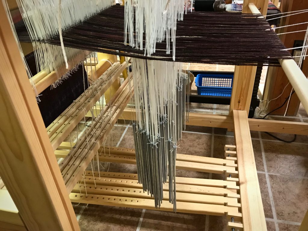 Weights hang on the pattern units in the drawloom.