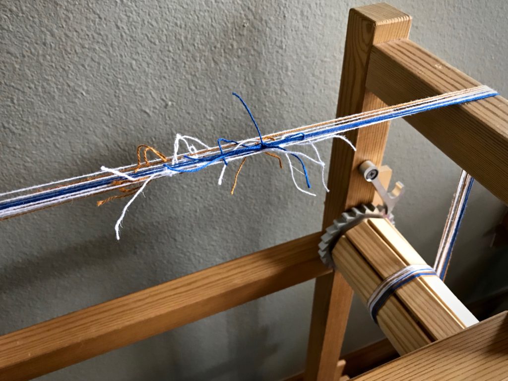 Thrums are used to make a warp for the Glimåkra band loom.