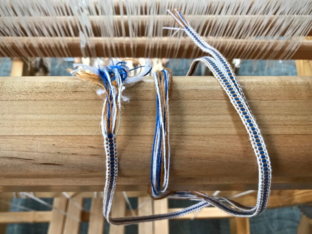 Woven band for hanging tabs on handwoven towels.