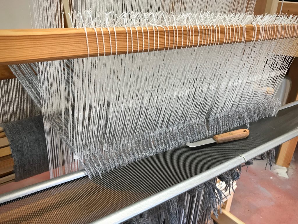 Sleying the reed on the drawloom.