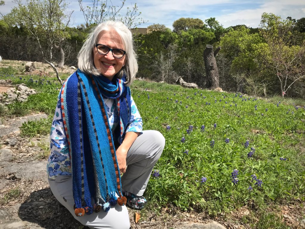 Winter scarf amid spring bluebonnets in Texas hill country.