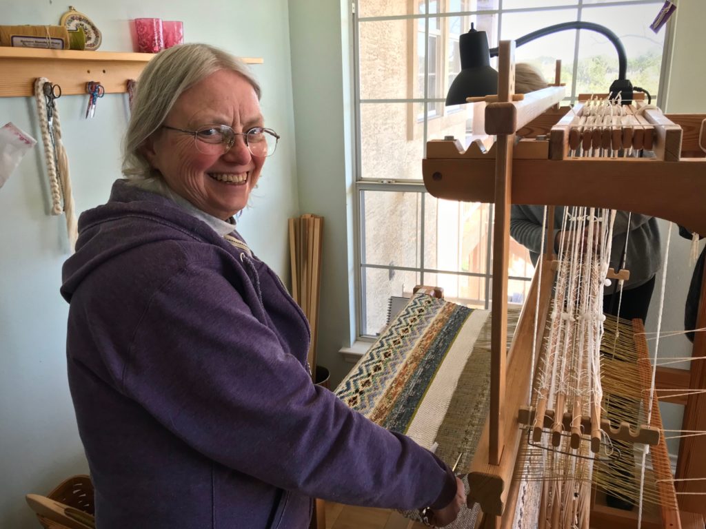 Joanne Hall does the honor of cutting off the rag rugs.