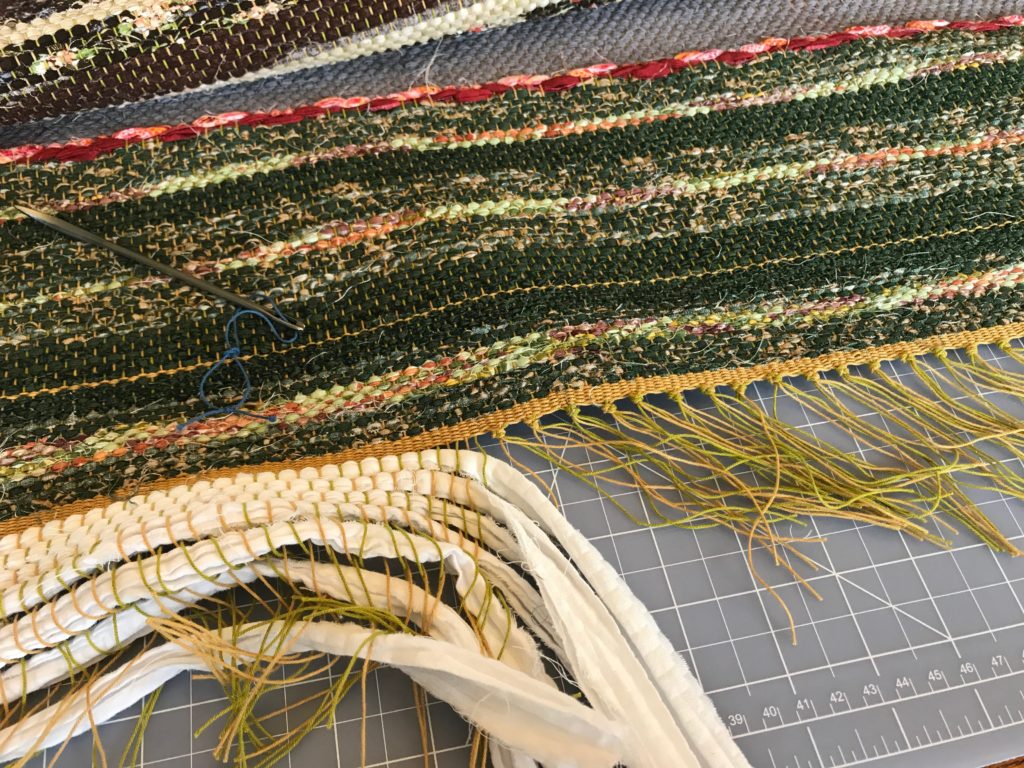 Tying knots to finish a rag rug.